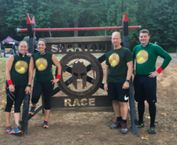 Chris and team posing in front of the signSpartan Race