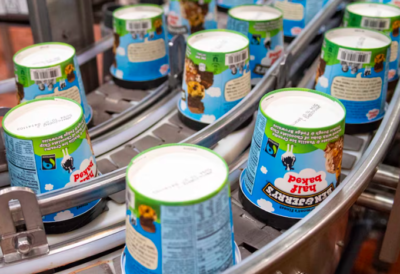 Ben and Jerry's pint ice cream containers facing upside down on a food conveyor belt