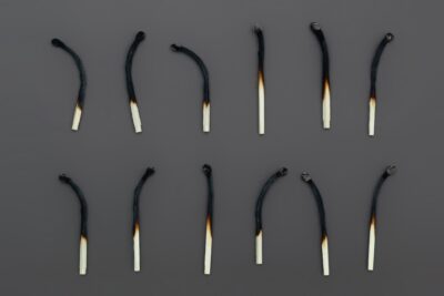 Two rows of half-burned matches on a gray cloth