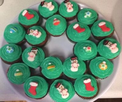 Chocolate cupcakes with Kelly green icing decorated with snowmen and stockings for Christmas