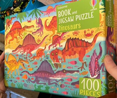 The cover of a brightly colored illustrated dinosaur puzzle.