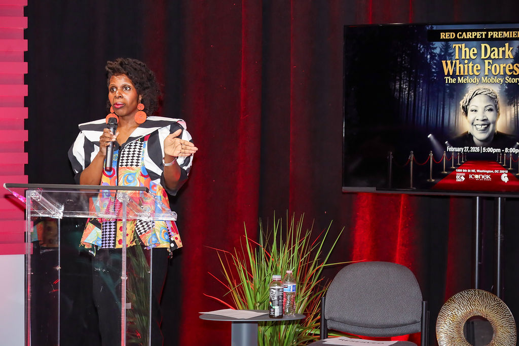 melody-2 Yaida Ford speaking at a podium during the premiere of The Dark White Forest.