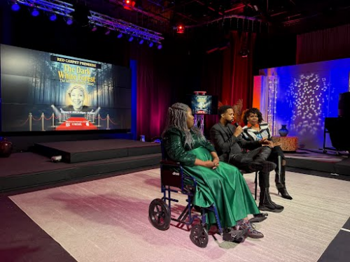 Three people are seated and facing an off-stage audience during a Q&A session.
