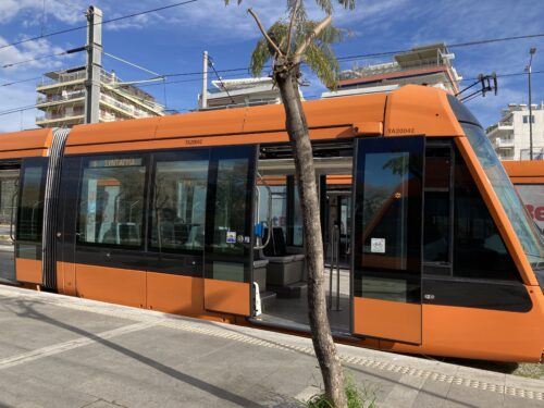 An orange tram awaits passengers to board it